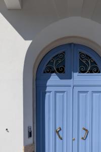 a blue door with gold handles on a white wall at Doride Suites Boutique Hotel in Marina di Carrara