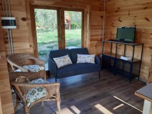 ein Wohnzimmer mit einem Sofa, Stühlen und einem TV in der Unterkunft Podere Oliveta in Montecatini Val di Cecina