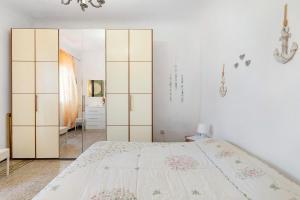 a white bedroom with a bed and a mirror at Dalla Ire in Lerici