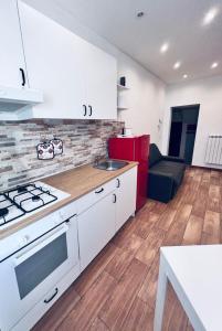 a kitchen with white cabinets and a stove top oven at Macario Apartment in the Old Town in Bari