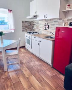 a kitchen with a red refrigerator and a table at Macario Apartment in the Old Town in Bari