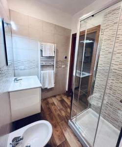 a bathroom with a sink and a glass shower at Macario Apartment in the Old Town in Bari