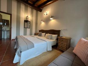 a bedroom with a large white bed and a couch at Posada La Vieja Escuela in La Revilla