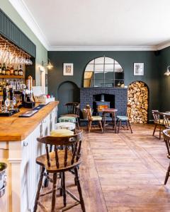 um bar com cadeiras e mesas e uma lareira em The Whichcote Arms 