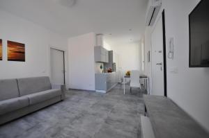 ein weißes Wohnzimmer mit einer Couch und einem Tisch in der Unterkunft Agriturismo Ca du Bega 2 in Arma di Taggia