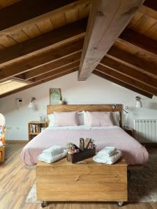 1 dormitorio con 1 cama grande con sábanas y almohadas rosas en La casa de las Flores de El Hornillo, en El Hornillo