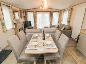 a dining table and chairs in a living room at 20 Wolds View in Ganton