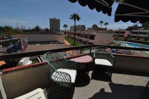 2 sillas y una mesa en un balcón con piscina en Apartment in Las Plataneras en Los Cristianos