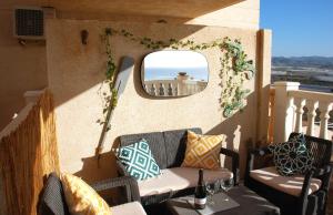 een balkon met een tafel en stoelen en een spiegel bij Casa Luna - Sea view apartment Bolnuevo in Bolnuevo