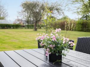 uma mesa de madeira com flores em cima em Holiday Home Filippus - 30km from the sea in Western Jutland by Interhome em Tønder