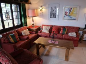 ein Wohnzimmer mit roten Sofas und einem Couchtisch in der Unterkunft Chalet Tgaplotta by Interhome in Alvaneu