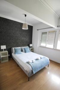 a bedroom with a large bed with blue pillows at Oriente DNA Studios VI in Lisbon