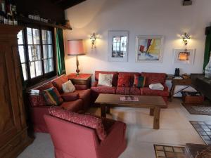ein Wohnzimmer mit roten Sofas und einem Tisch in der Unterkunft Chalet Tgaplotta by Interhome in Alvaneu