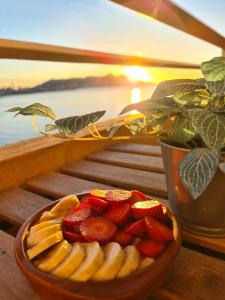 a bowl of bananas and strawberries on a table with the sunset at Bonito triplex con increíbles vistas in Benidorm