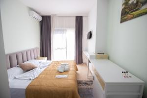 een kleine slaapkamer met een bed en een bureau bij VILA SANREMO in Tirana