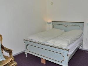 a bed with white pillows and a chair in a room at Apartment Hendricke - 22km from the sea in Western Jutland by Interhome in Bredebro