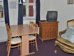Bredebro的住宿－Apartment Hendricke - 22km from the sea in Western Jutland by Interhome，一间配备有桌子、电视和椅子的客房