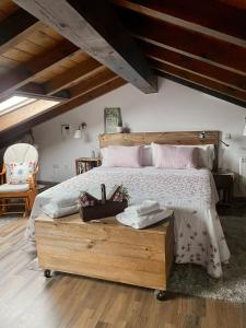 Un dormitorio con una gran cama de madera con almohadas rosas en La casa de las Flores de El Hornillo, en El Hornillo
