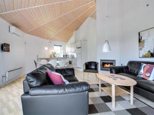 a living room with black leather furniture and a table at Holiday Home Jani - 25km from the sea in Western Jutland by Interhome in Toftlund