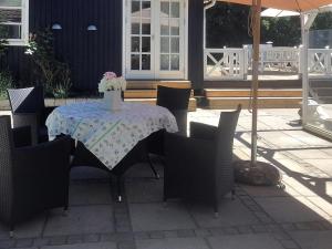 una mesa con sillas y un jarrón de flores. en Holiday Home Jeip - 400m to the inlet in Sealand by Interhome, en Holbæk
