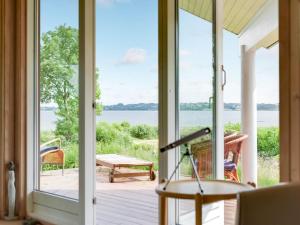 a screened porch with a view of the water at Holiday Home Brunman - 10m to the inlet in Sealand by Interhome in Grevinge