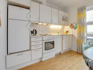 cocina blanca con electrodomésticos blancos y mesa en Apartment Arngerus in Western Jutland by Interhome en Højer