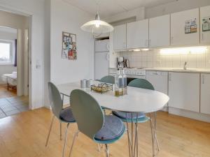 Apartment Arngerus in Western Jutland by Interhome في Højer: مطبخ مع طاولة بيضاء وكراسي