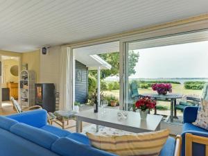 a living room with a blue couch and a table at Holiday Home Eddy - all inclusive - 50m from the sea by Interhome in Kragenæs