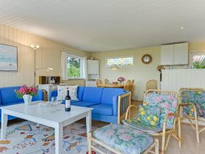 a living room with a blue couch and chairs at Holiday Home Eddy - all inclusive - 50m from the sea by Interhome in Kragenæs