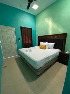 - une chambre avec un grand lit aux murs bleus dans l'établissement Hotel Murallas Capital, à Campeche