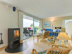 a living room with a fireplace and a table with chairs at Holiday Home Eddy - all inclusive - 50m from the sea by Interhome in Kragenæs
