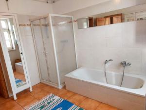 een witte badkamer met een bad en een douche bij Holiday Home Parkblick by Interhome in Heyda