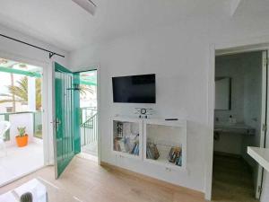 een woonkamer met een flatscreen-tv aan de muur bij Costa Guacimeta Apartment in Los Pocillos