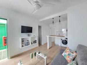 een witte woonkamer met een bank en een keuken bij Costa Guacimeta Apartment in Los Pocillos