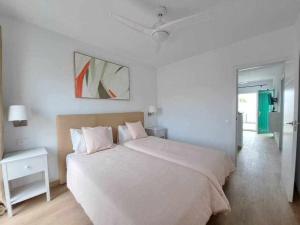 een witte slaapkamer met een groot bed en een tafel bij Costa Guacimeta Apartment in Los Pocillos +12 foto's