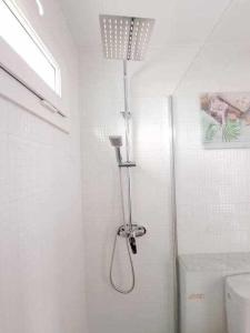 een douche in een witte badkamer met een toilet bij Costa Guacimeta Apartment in Los Pocillos