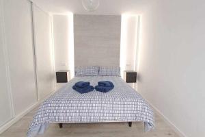 a bed with two blue towels on top of it at ARQ Home Arrecife in Arrecife