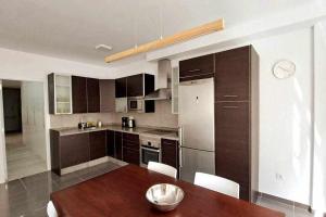 a kitchen with a wooden table and a dining room at ARQ Home Arrecife in Arrecife +4 photos