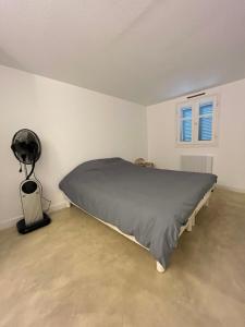 een slaapkamer met een bed en een ventilator. bij Duplex apartment in a residence with swimming pool near Cannes in Le Cannet