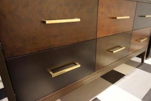 a wooden dresser with gold handles on a checkered floor at LiA Hotel in San Carlos