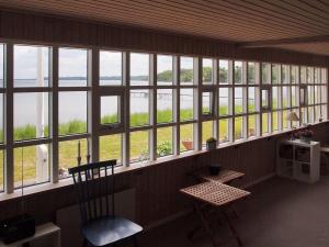 um quarto com janelas, uma cadeira e uma mesa em Holiday Home Udder - 50m to the inlet in SE Jutland by Interhome em Aabenraa