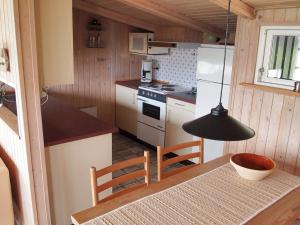 uma pequena cozinha com uma mesa e um candeeiro preto em Holiday Home Udder - 50m to the inlet in SE Jutland by Interhome em Aabenraa
