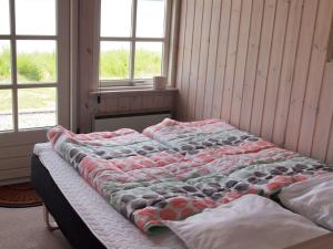 uma cama grande num quarto com duas janelas em Holiday Home Udder - 50m to the inlet in SE Jutland by Interhome em Aabenraa