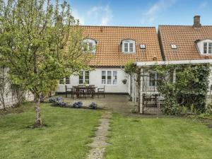 uma casa branca com uma mesa e cadeiras num quintal em Holiday Home Ajna - 9-8km from the sea in Western Jutland by Interhome em Tønder