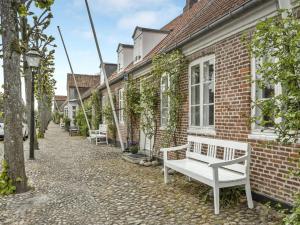 a white bench sitting outside of a brick building at Holiday Home Ajna - 9-8km from the sea in Western Jutland by Interhome in Tønder