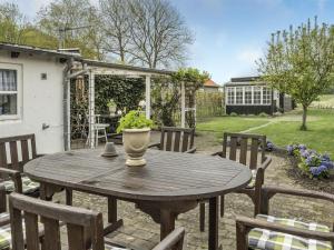 einem Holztisch mit Topfpflanze auf einer Terrasse in der Unterkunft Holiday Home Ajna - 9-8km from the sea in Western Jutland by Interhome in Tønder