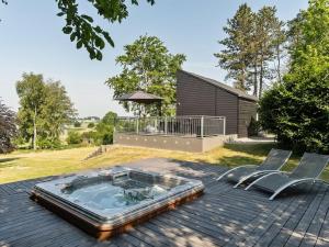 uma banheira de hidromassagem num deque com 2 cadeiras em Holiday Home Harka - 100m to the inlet in Sealand by Interhome em Roskilde