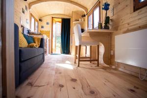 a tiny house with a dining room and a living room at L'encantada- Roulotte in Rieux