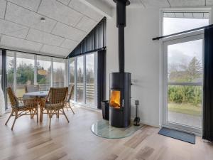 sala de estar con chimenea, mesa y sillas en Holiday Home Heide - 750m to the inlet in Western Jutland by Interhome, en Tarm