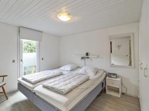two beds in a white room with a window at Holiday Home Pinja - 40km from the sea in SE Jutland by Interhome in Silkeborg